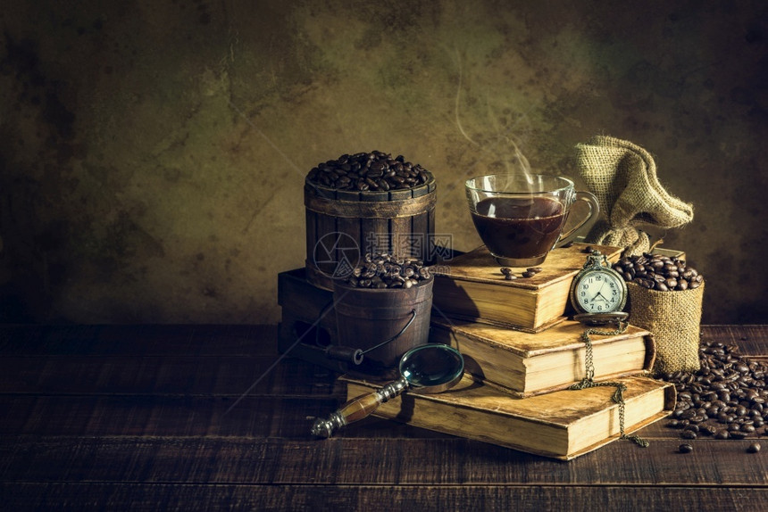 老的地面古旧书籍中的咖啡杯和老木地板上的时钟年表豆图片
