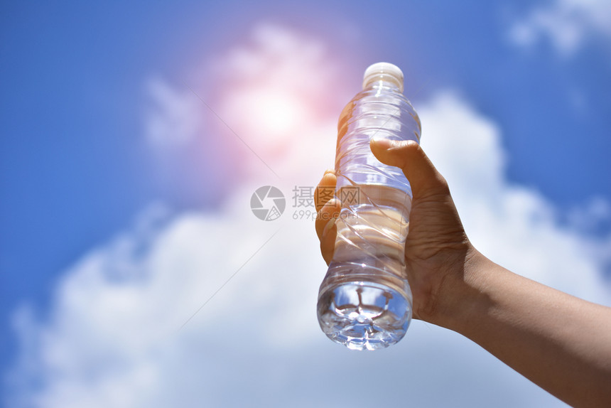 美丽的手持饮用水蓝天云底的背景热女士图片