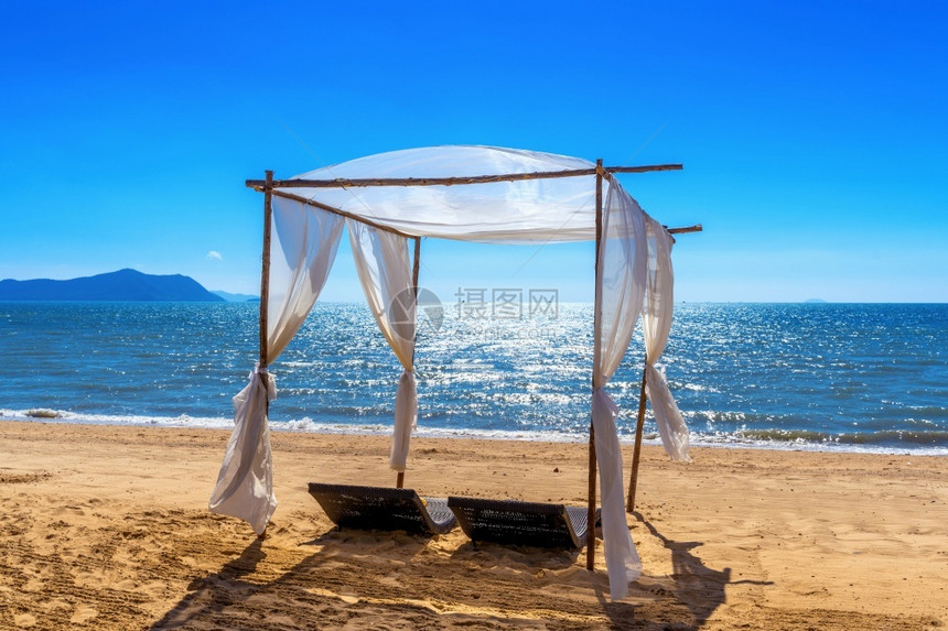 小屋白色的舱沙滩树冠海上有太阳护晒员图片