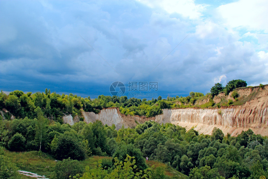 地质学粉饰山脚有森林的桑迪山峰天色景观白粉板岩采石场和沙悬崖与雷暴雨天空的陆地风景CrawkCreatherousJestics图片
