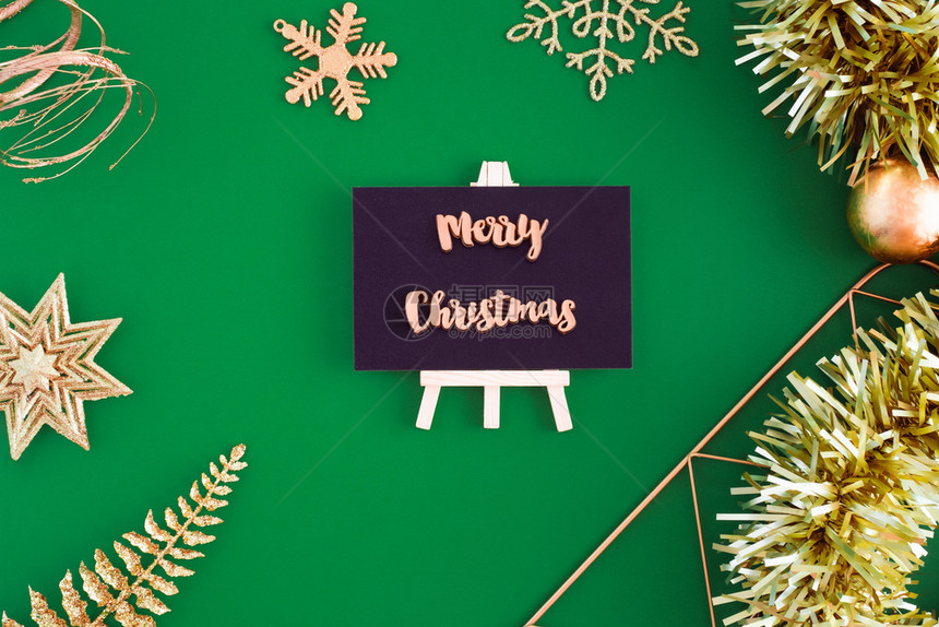 前夕绿色展示黑板顶端的圣诞快乐有黄金圣诞节和新年装饰品绿纸背景喜庆贺卡上写着新的一年装饰品图片