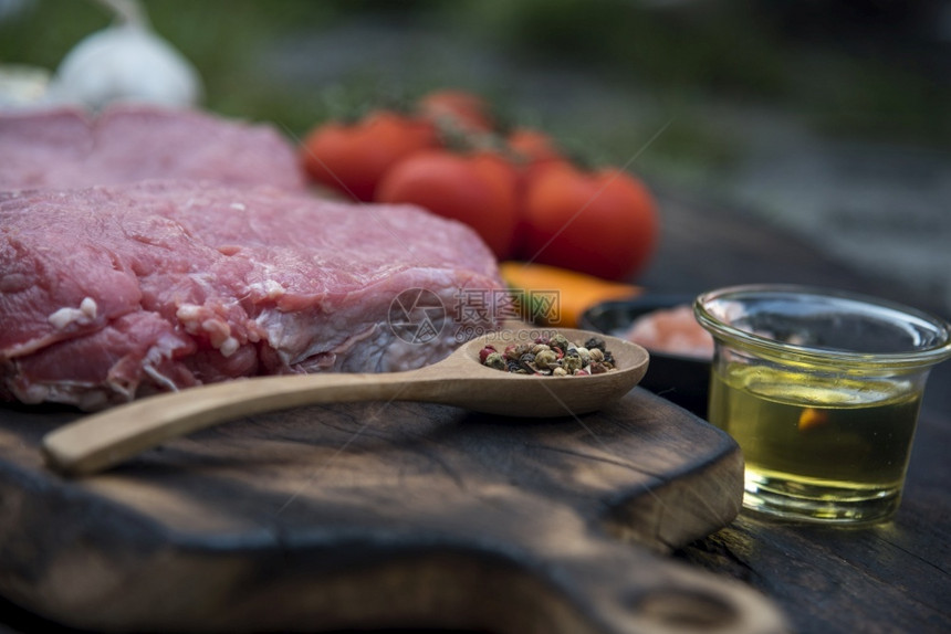 牛肉排木板上未煮熟烹饪的牛肉排成分顶端视图用于政党西方食品户外新鲜肉辣椒橄榄油大蒜番茄盐和迷迭香红色的复制食物图片