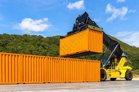 手术码头在商业进口出中处理集装箱货运的卡车有货集箱车堆的物流运输船场和货集装箱车库起重机背景