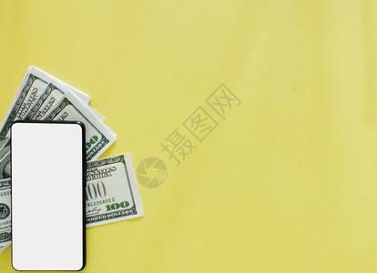 工作空白的色屏幕智能手机黄底带美元钞票的白纸笔银行业图片