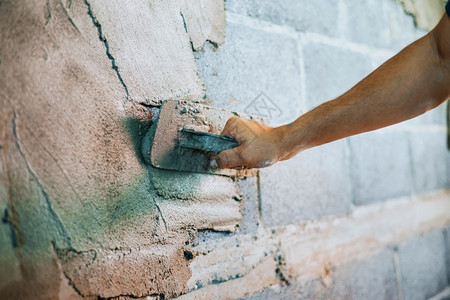 建筑学重新装修工人们在建筑房屋墙上涂水泥的紧手工匠背景图片