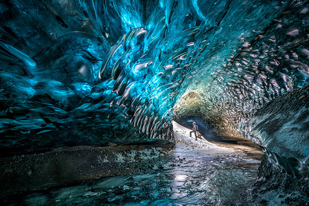 远足冒险家冰洞让一个人看在洞口流过面户外高清图片