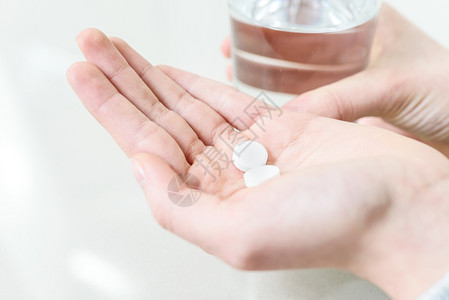 止痛药喝抗生素治疗概念形象青年妇女用药丸和水亲近的手图片
