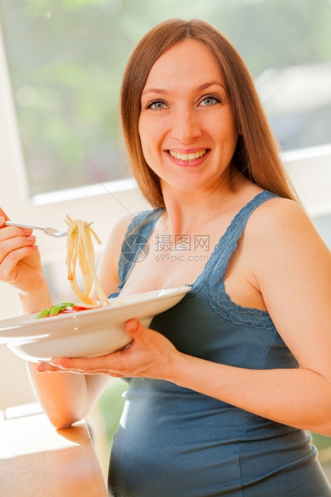 可口孕妇用番茄酱吃大部份意利面粉的相片饥饿图片