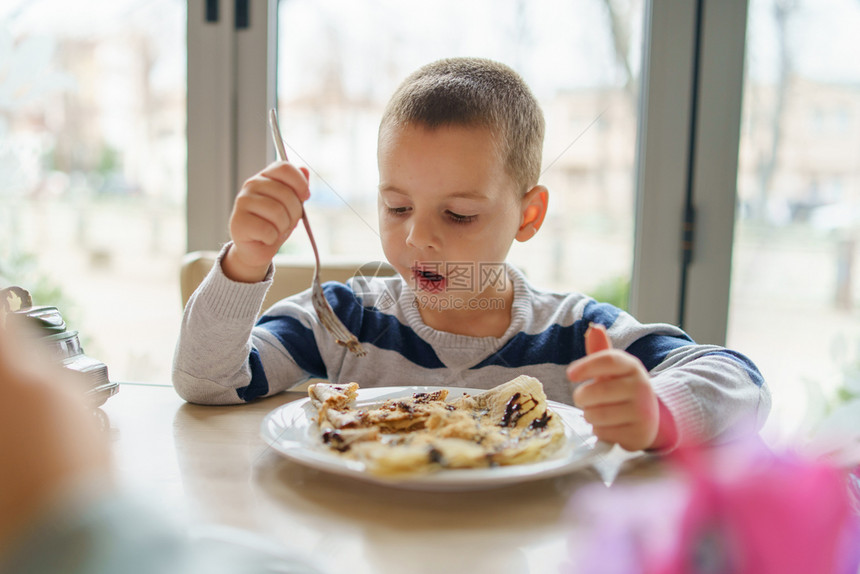 食物愉快一顿饭坐在家桌边或餐厅吃煎饼叉子桌边的小可爱男孩caucasiansian的肖像图片