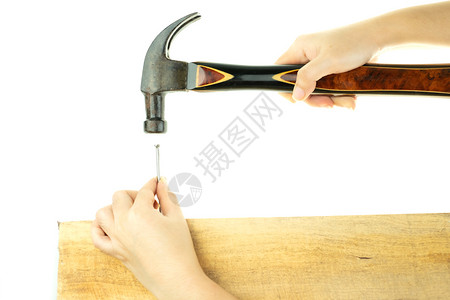 女士握手打锤子在白色背景时钉木头上长弯曲工具图片