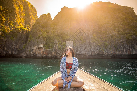 小船上的女孩日落感的在泰国普吉岛菲济MayaBayPhiPhi岛马雅湾的长尾船上年轻的背景