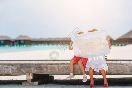 姐带大的小女孩在海滩上选择下一站带大的小女孩在热带海滩度假的小可爱女孩蓝色的水图片