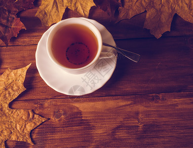 一杯秋冬热茶和秋叶图片