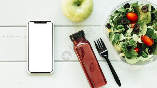 闲暇照片拍带有智能手机沙拉的健康食品概念图片