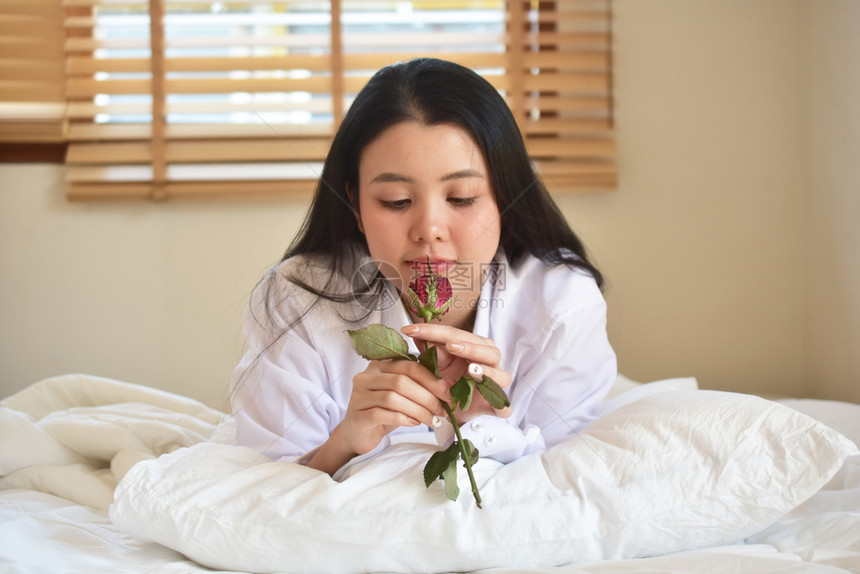 人们放松快乐的有玫瑰花年轻美女睡在卧室图片