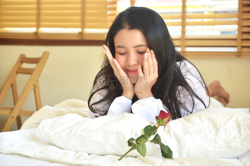 成人有玫瑰花的年轻美女睡在卧室孩迷人的图片