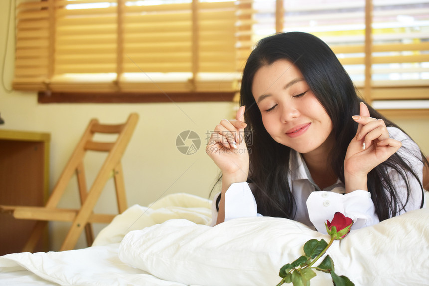 健康床女有玫瑰花的年轻美女睡在卧室图片