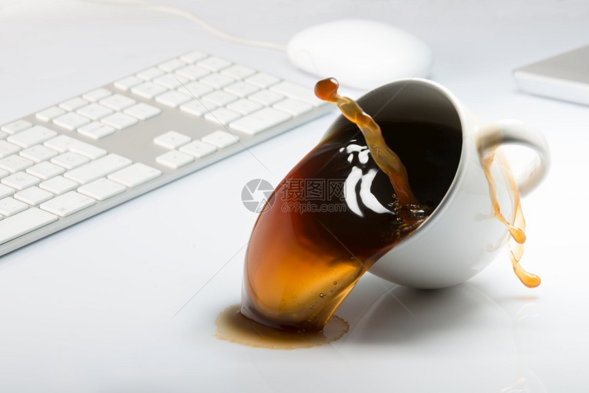 在室内用电脑桌子顶上掉落和溢出一杯咖啡的喝办公室图片