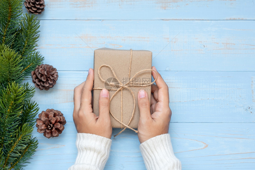 持有礼品盒圣诞装饰和木背景的松树枝节日概念准备新年快乐和Xmas假日顶端风景等礼物盒的妇女手季节图片