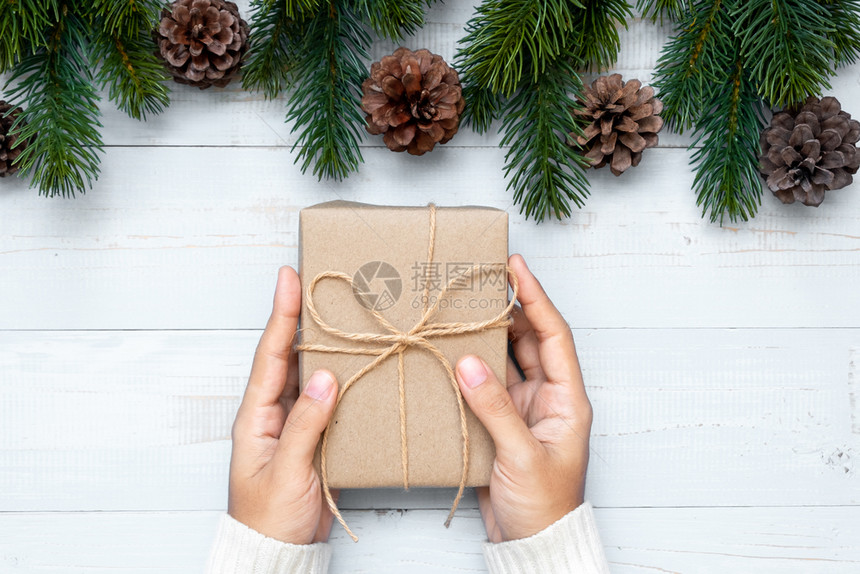 持有礼品盒圣诞装饰和木背景的松树枝节日概念准备新年快乐和Xmas假日顶端风景等礼物盒的妇女雪帕努瓦季节图片