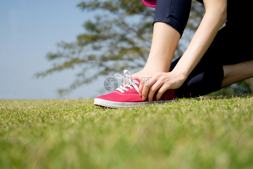 合身跑鞋将妇女紧贴在赤脚跑鞋上系带的妇女关上运动员准备到户外慢跑脚丫子重量图片