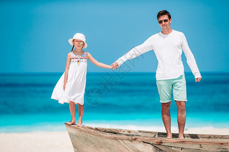 快乐的父亲和他可爱小女儿在沙滩上玩图片
