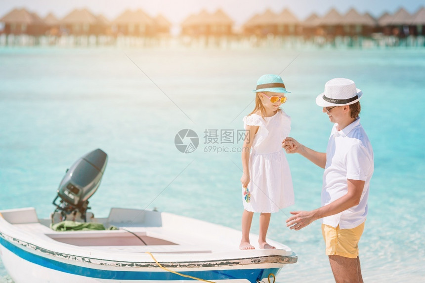 绿松石他的快乐父亲和他可爱小女儿在海滩上小女孩和快乐爸在海滩度假期间玩得开心的快乐爸趣图片