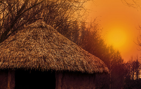 茅草根苫景观旅行一个原始家的屋顶日落时有根稻草屋顶自然风景美丽的地貌背景背景