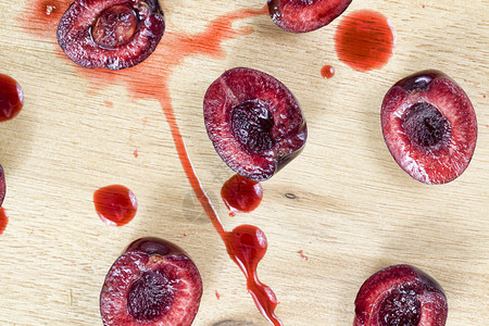 白木桌上的红甜樱桃切片准备用于烹饪的红甜樱桃切片柜台楔多汁的图片