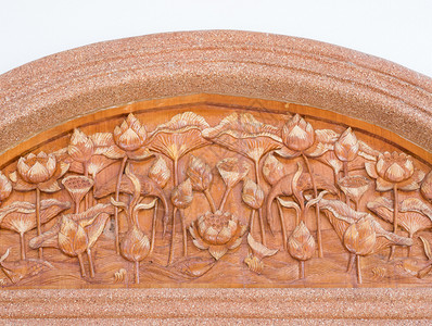 柚木华丽的寺庙位于教堂门上墙壁的茶板Lotus雕刻物背景图片