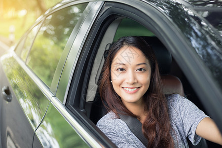 汽车美丽的亚洲女在路上驾车旅行时微笑和愉快地开车轮年轻的图片