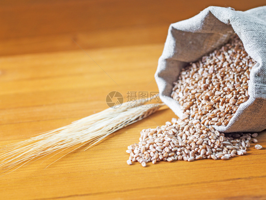 粮食谷物木背上装满小麦和耳朵的袋子木制背景上装满小麦和耳朵的袋子农业图片