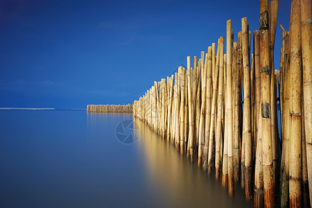 竹栅栏保护沙滩免受海浪影响图片