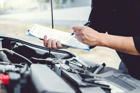 电池汽车衣领在车库工作的汽修理技术员在汽车修理服务和维汽车检查中工作的汽车修理手燃料收费背景