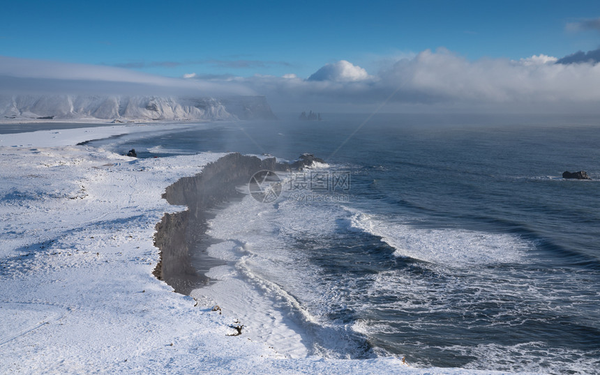 欧洲风景冰岛Dyrholaey角海岸景观的全图象在冬季与积雪覆盖海岸线的冰岛沿图片