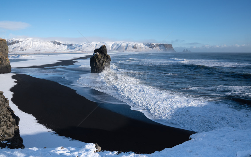 海滩白雪皑冰岛Dyrholaey角海岸景观的全图象在冬季与积雪覆盖海岸线的冰岛洋图片