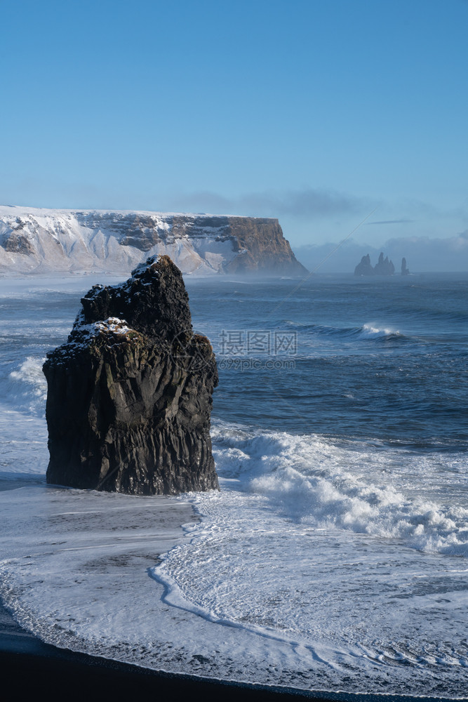 环境岬冰岛Dyrholaey角海岸景观的全图象在冬季与积雪覆盖海岸线的冰岛洋图片