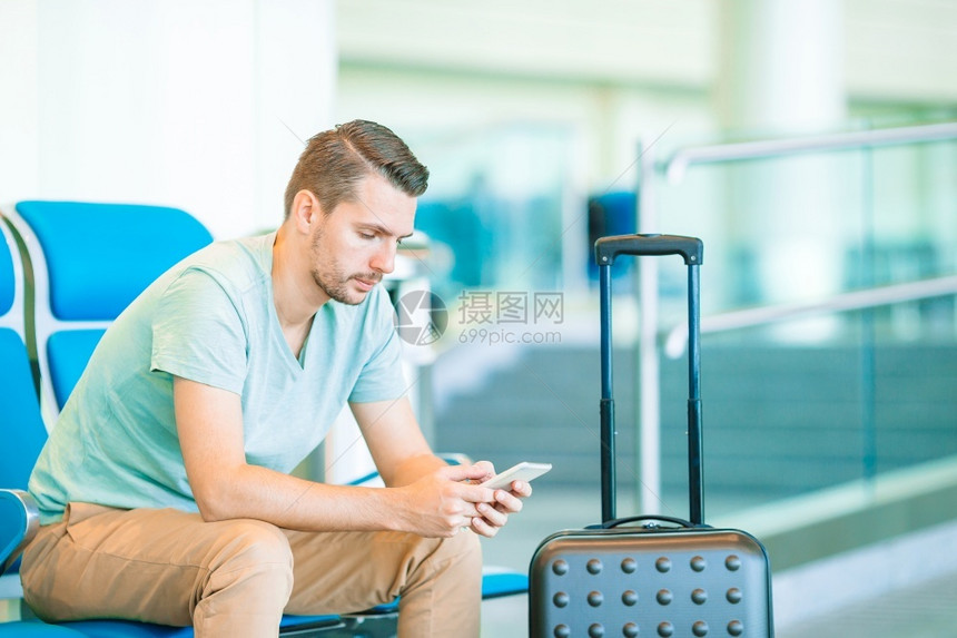 离开云男生在机场休息室等待飞行机的航空公司乘客在机场休息室等待飞行机的年轻人图片