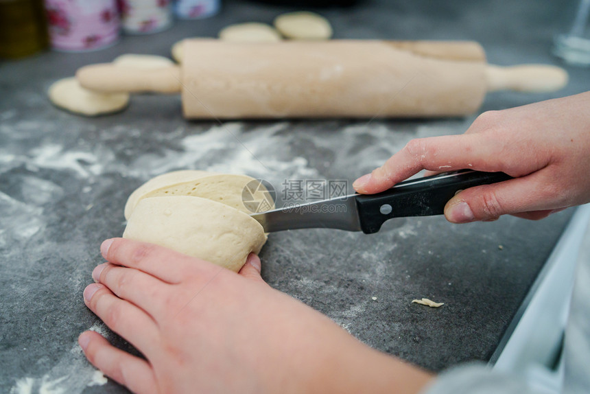 面团近距离靠不明的caucasian女子的手在家庭边视线厨房桌上用刀子做面包切粉糕饼的女孩面包师白种人图片