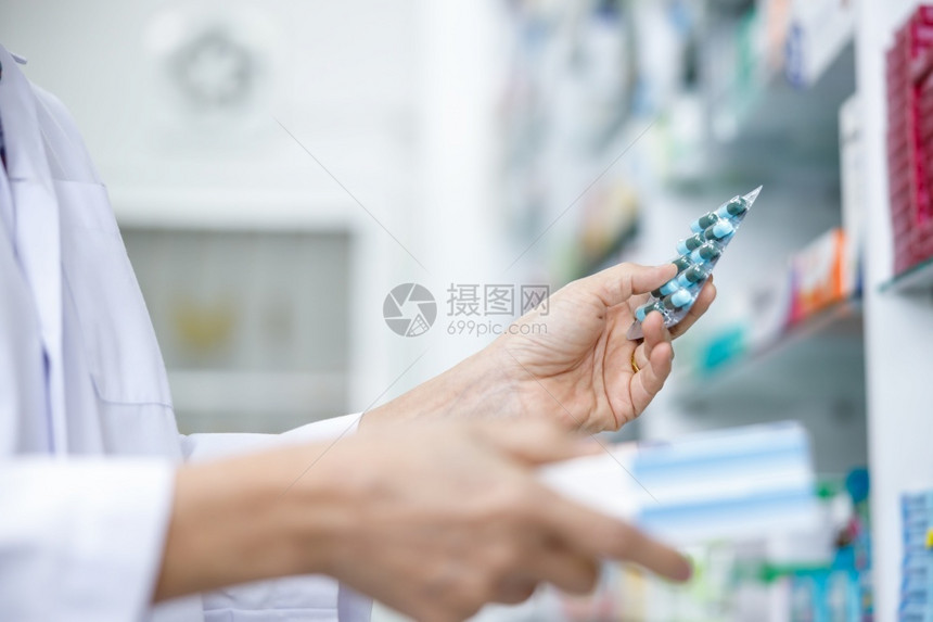 制药帮助医院泰国店手持胶囊袋的女医生在泰国药店持有胶囊包图片