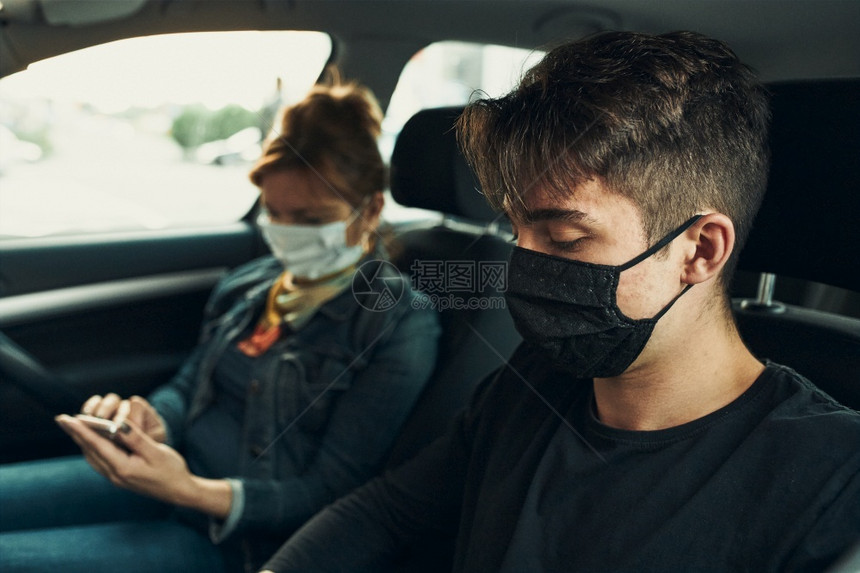 坐在车里的男女都佩戴面罩避免感染病毒图片