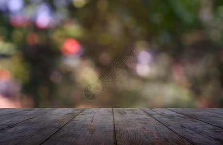 白天树在花园和自然光背景的抽象模糊绿色面前的空木制桌用于蒙太奇产品显示或设计关键视觉布局图像散焦背景图片