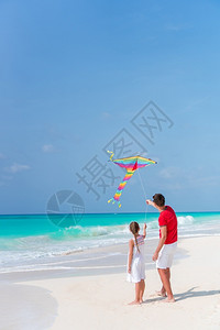 爸和孩子一家在沙滩上玩风筝图片