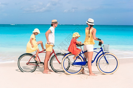 孩子在热带海滩上骑自行车的家庭在热带海滩上骑自行车的家庭旅图片
