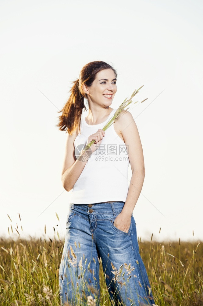 外出画像一个美丽的女人在夏日拿着花朵的外门肖像农村漂亮的景观图片