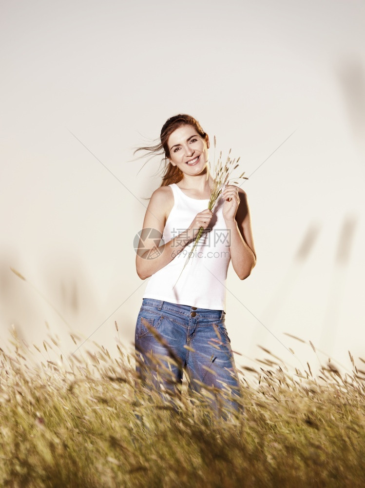 夏天外出画像一个美丽的女人在夏日拿着花朵的外门肖像户年轻的图片