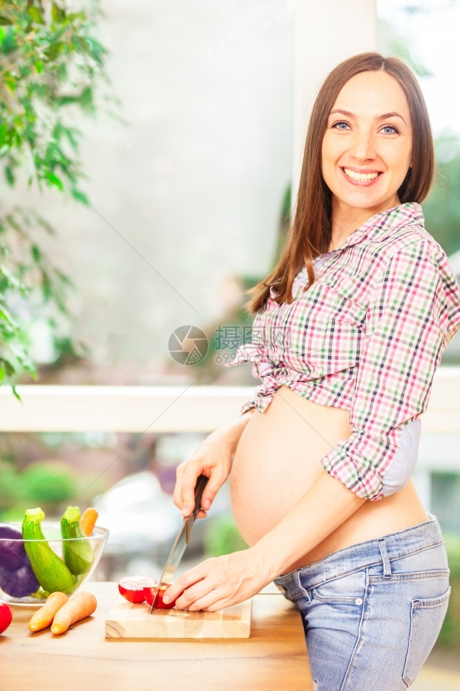 随意的刀怀孕妇女在家中做饭的相片母亲图片