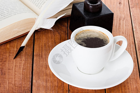 糖早晨咖啡杯配有钢笔和木制背景书上的墨水黑色图片