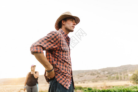 场地夏天戴帽子在田里工作的农民方格图片