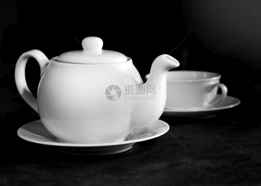 新鲜的咖啡店白瓷茶杯和壶下午桌布置黑白图片